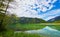 Beautiful Offensee lake landscape with mountains, forest, clouds and reflections in the water in Austrian Alps