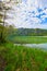 Beautiful Offensee lake landscape with mountains, forest, clouds and reflections in the water in Austrian Alps