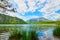 Beautiful Offensee lake landscape with mountains, forest, clouds and reflections in the water in Austrian Alps