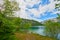 Beautiful Offensee lake landscape with mountains, forest, clouds and reflections in the water in Austrian Alps