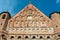 A beautiful old fortress church made of red brick against a blue sky background. A high impregnable fortress with iron crosses on