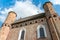 A beautiful old fortress church made of red brick against a blue sky background. A high impregnable fortress with iron crosses on