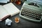 Beautiful old gray typewriter, book and a glass with alcohol