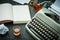 Beautiful old gray typewriter, book and a glass with alcohol