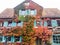 Beautiful old house with turquoise shutters and colorful autumn leaves on the facade