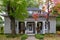 Beautiful old shingled-roofed Regency style house with Halloween display on its porch