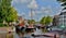 Beautiful old ships on channel. Colorful picture taken in sunny day when white clouds were on the sky. Historic builds, Holland.