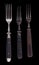 Beautiful old vintage forks isolated on black background. Top view. Retro silverware