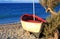 Beautiful old weathered wooden fishing boat on pebble beach at sunrise