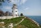 Beautiful old white lighthouse on the sea coastline. Summer seascape