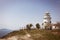 Beautiful old white lighthouse on the sea coastline. Summer seascape.