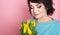 Beautiful old woman with professional smokey make-up and hairstyle holding tulip flowers on the pink background