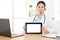 Beautiful online doctor showing tablet computer