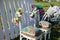 Beautiful open terrace in the garden with tiffany coloured vintage white chairs, colorful velvet pillow and fence palisade