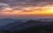 A beautiful orange and pink sky over layered silhouetted mountains during sunset. Kings Canyon National Park