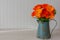 Beautiful orange silk gerbera daisies in blue antique watering can