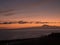 Beautiful orange sky before sunrise over calm ocean and silhoutte of mountain pico del Teide at Tenerife seen from La