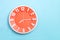 Beautiful Orange wall clock on blue background ,concept of Start the morning to work