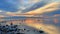 Beautiful orange and yellow sunset mirrored in the tranquil, still waters of a lake near a shoreline