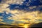 Beautiful ornage yellow color sunset over atacama desert with cumulus and cirrus clouds, sun burst star effect - Chile