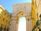 Beautiful ornate archway gate with clock in Lisbon Portugal against blue sky.