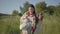 Beautiful overweight woman walking in wild high grass with the earthen jar in the green summer field. Beautiful