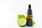 Beautiful packshot of Bergamot essential oil in a small glass bottle with fresh bergamot fruit with green leaf on white background