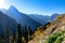 Beautiful panorama of high rocky mountains with snow-capped peaks, mighty glaciers and bright autumn forest in yellow