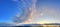 Beautiful panorama of orange and yellow cloudscapes at sunrise/sunset  on a blue sky in high resolution