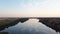 Beautiful panorama of river going to horizon and reflecting blue sky. Footage. River surface reflects beautiful blue sky