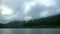 Beautiful panorama video view of morning reservoir lake water lush tropical mountain forest with cloud and fog