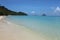 Beautiful panorama wallpaper shot of a paradisiac white sand beach with crystal clear turquoise ocean water, deep blue sky with