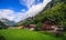 Beautiful panoramic postcard view of picturesque rural mountain scenery in the Alps with traditional old alpine mountain chalets