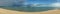 Beautiful panoramic sea view and clean beach wth three island and rainy cloud coming from left side of picture, colouful blue