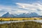 Beautiful panoramic view of blue water river with golden yellow grass with background of nature mountains peak with cloud in