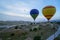 Beautiful panoramic view of colorful balloons flying above Cappadocia unique landscape ground with blue sky background at sunrise