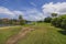 Beautiful panoramic view of hotel grounds with golf course on blue sky with white clouds in background.