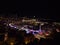 Beautiful panoramic view of the illuminated downtown of Monaco at night with funfair and marina Port Hercule.