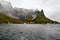 Beautiful panoramic view of the ocean and a small village at the coast with snowcapped mountains in the background on Lofoten Isla