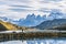 Beautiful panoramic view small people standing at the dock from the lake with Cuernos, horn mountains peak with lenticular cloud