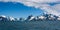 Beautiful panoramic view of South Georgia mountains and coastline from the sea, blue Atlantic ocean, snow coved mountains, blue sk