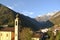 Beautiful panoramic view to mountain village in valley under mountains in a summer sunny weather.