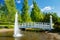 A beautiful park with a pond, wooden bridge and fountain in sunny summer day