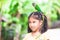 Beautiful parrot birds standing on child head. Asian child girl play with her pet parrot bird with fun