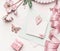 Beautiful pastel pink layout with flowers decoration,ribbon, hearts and card mock up on white desk background, top view, flat lay.