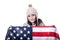 Beautiful patriotic vivacious young woman with the American flag held in her outstretched hands standing in front of an