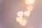 Beautiful pattern from bokeh sparkling garland lights in heart shape on pastel pinkish background. Valentine romantic love charity