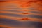 Beautiful patterns of blue-red-orange color on the undulating surface of the lake