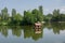 Beautiful peaceful nature, trees and plants on a lake, floating bird house, summertime season, reflection in the water