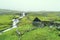 Beautiful peaceful rock house with green grass on the roof in Saksun valley next to the waterfall in foggy weather, Faroe Islands